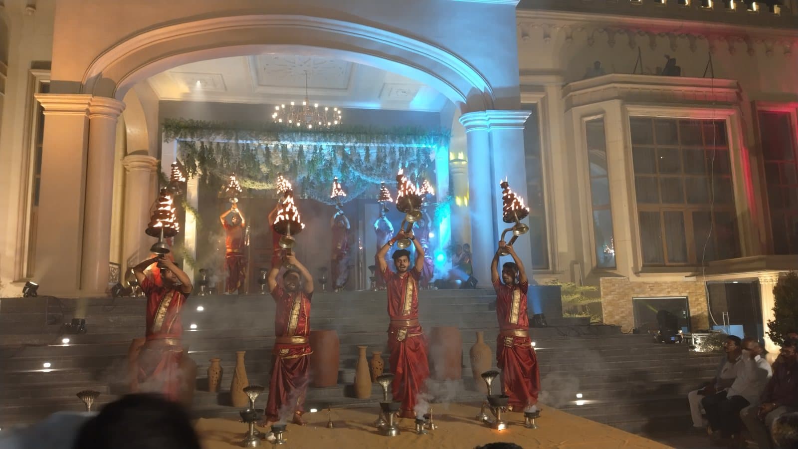 Pandits performing Aarti on a lit stage